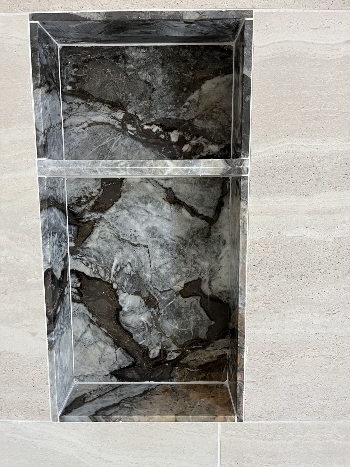 Project 1 custom marble shower niche with dramatic dark veining and precise stone detailing